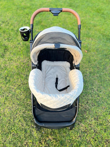 Top-down view of the beige plush cushion set fitted inside a Pawbella Ultimate Pet Stroller